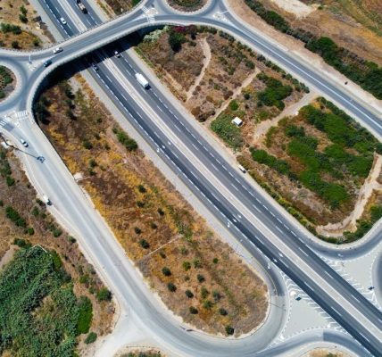 Top-down aerial view showcasing highways and roundabouts intertwined with greenery.