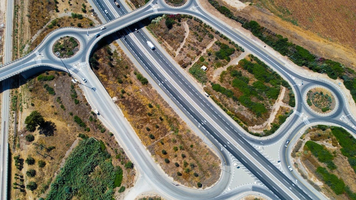 Top-down aerial view showcasing highways and roundabouts intertwined with greenery.